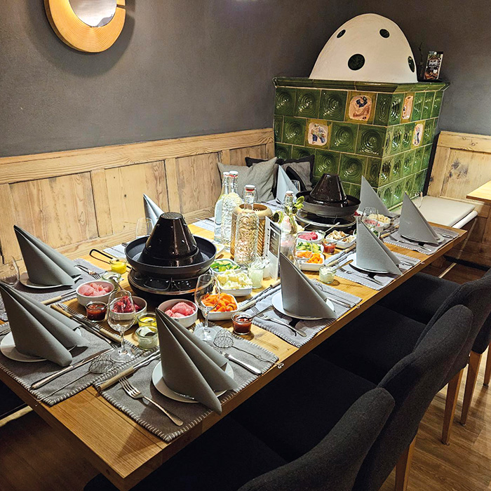 Gedeckter Tisch mit Essen, Käsefondue und Racelette